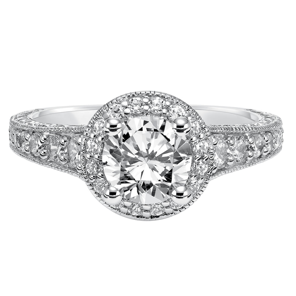 This show-stopping engagement ring is sure to impress with its diamond prong set halo and band with milgrain and engraving.  Center Stone is not included.