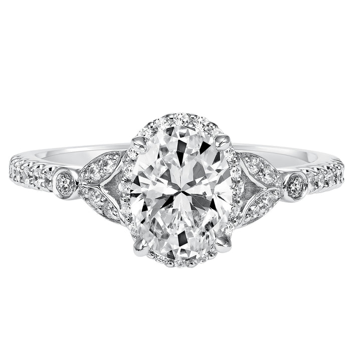 This romantic and beautiful engagement ring features an oval cut diamond accentuated by a prong set diamond halo and petal-inspired band design.  Center Stone is not included.