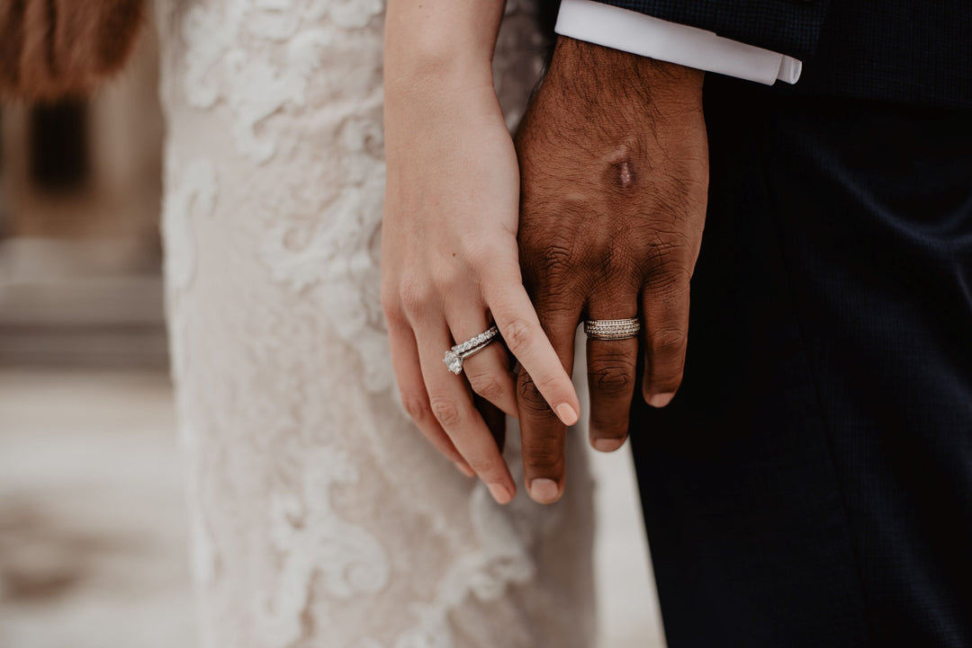 bride and groom holding hands with wedding rings