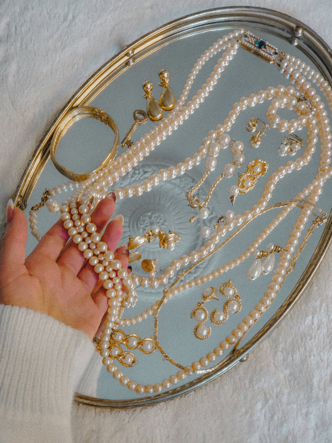 pearl jewelries flat lay on a mirror